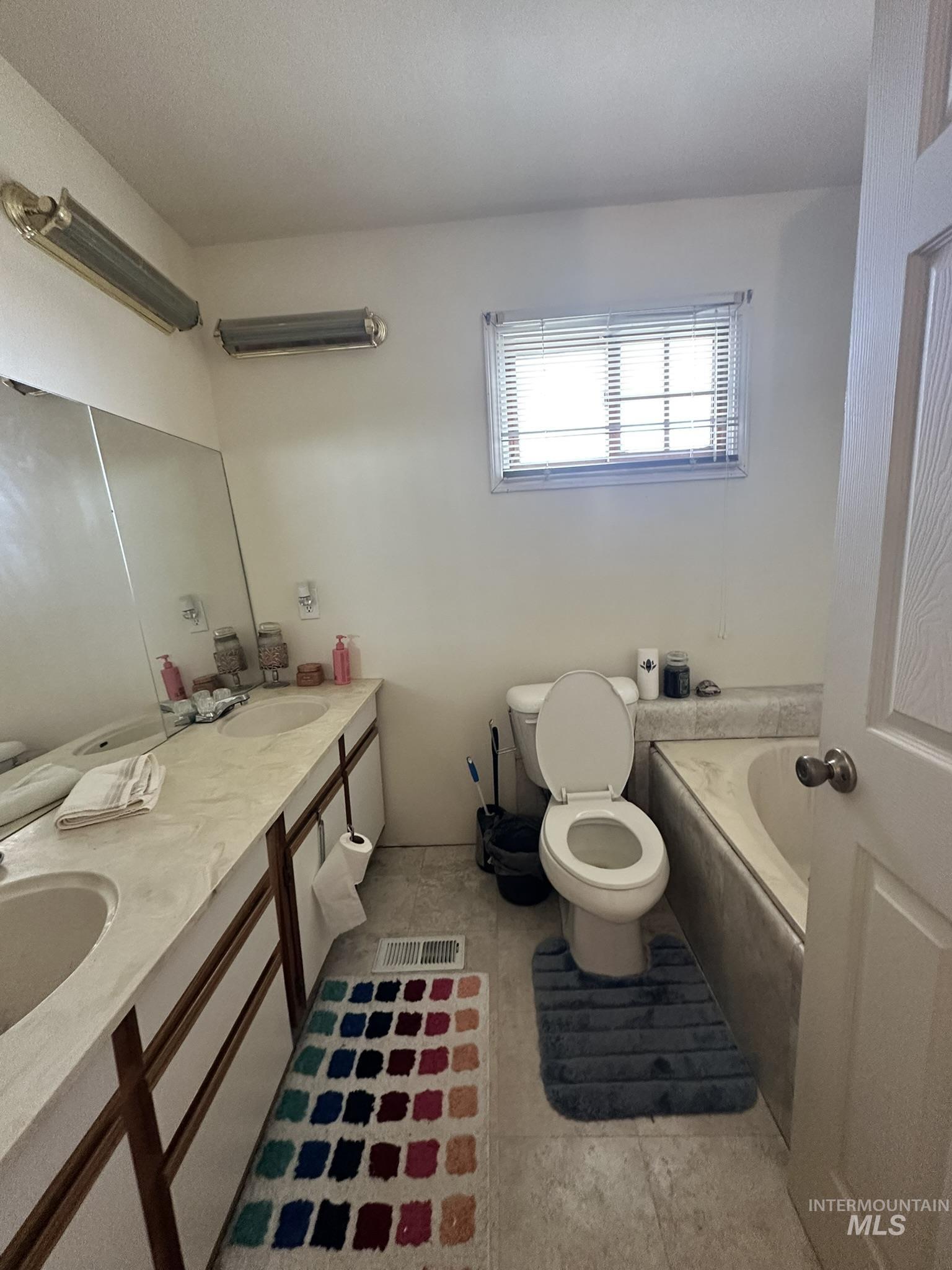 6750 Dearborne Road Nampa, ID 83686 - Photo 17 of 26 Bathroom with a garden tub, double vanity, and light tile patterned floors