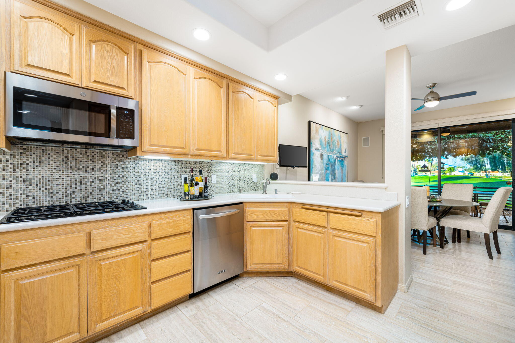 702 Inverness Drive Rancho Mirage, CA 92270 - Photo 22 of 49 a kitchen with stainless steel appliances granite countertop a stove a sink and white cabinets with wooden floors