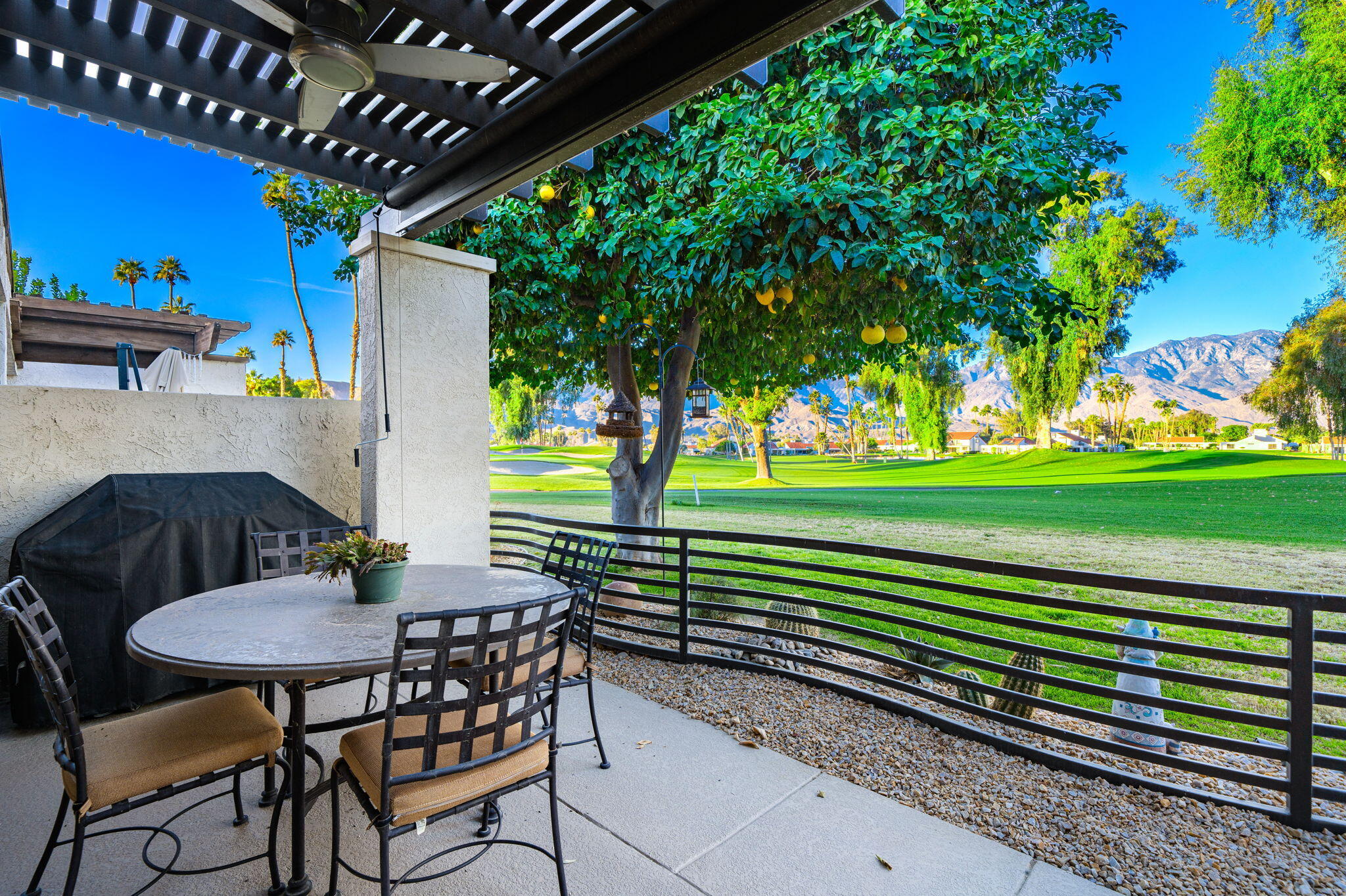 702 Inverness Drive Rancho Mirage, CA 92270 - Photo 27 of 49 a view of a chairs and table in patio with a yard