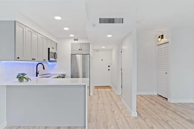 a kitchen with stainless steel appliances granite countertop a refrigerator sink and wooden cabinets