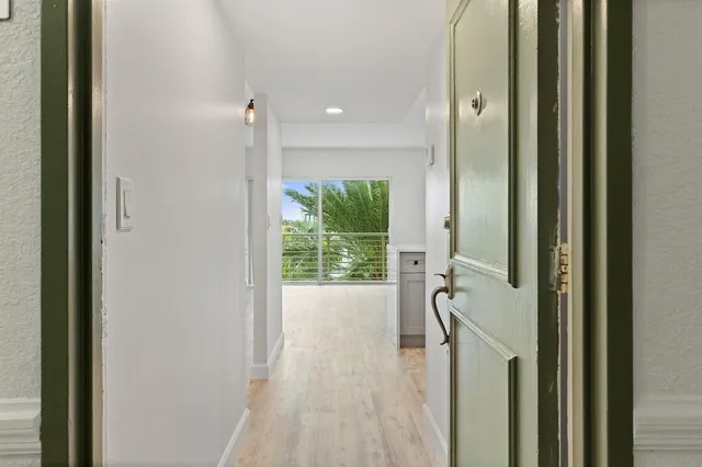 a view of a hallway with wooden floor and windows