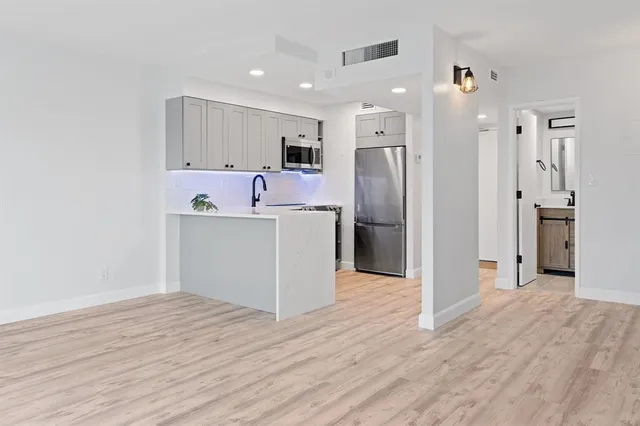 a view of a kitchen with wooden floor and a refrigerator