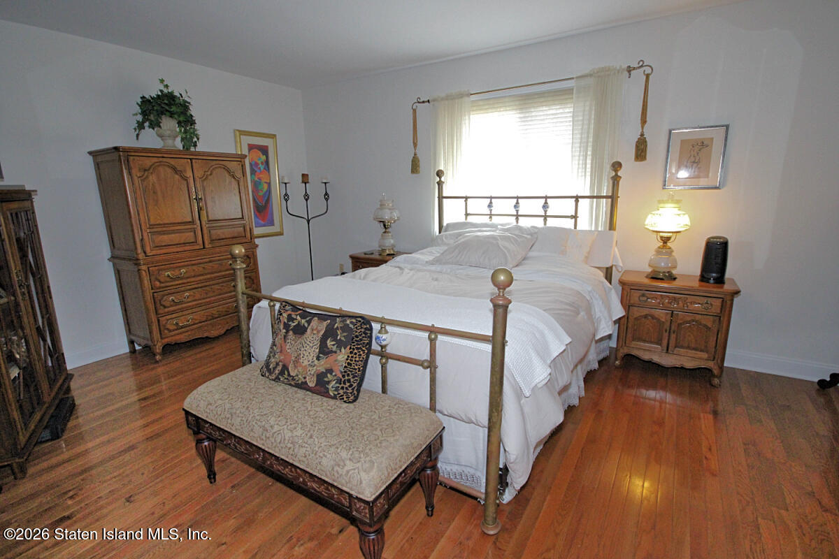 951 West Fingerboard Road Staten Island, NY 10304 - Photo 12 of 29 a bedroom with a bed a dresser and a large mirror