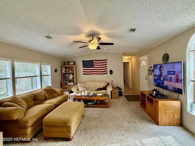 a living room with furniture ceiling fan and a window