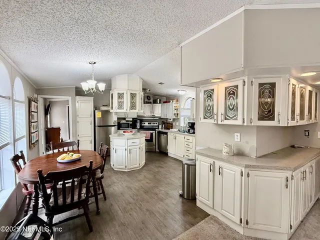 a kitchen with white cabinets and refrigerator