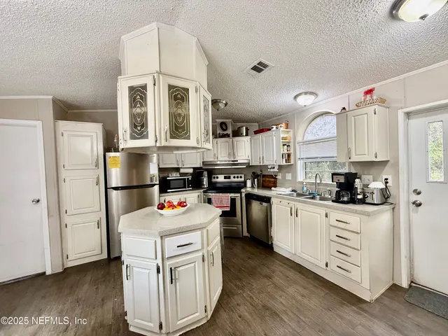a kitchen with stainless steel appliances granite countertop a stove refrigerator and cabinets
