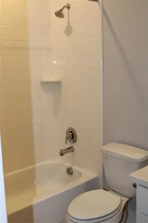 a white toilet sitting next to a bath tub