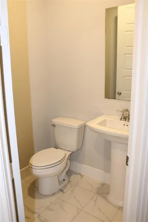 a white toilet sitting next to a bathroom sink