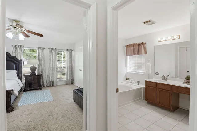 a bathroom with a sink double vanity mirror and a bathtub