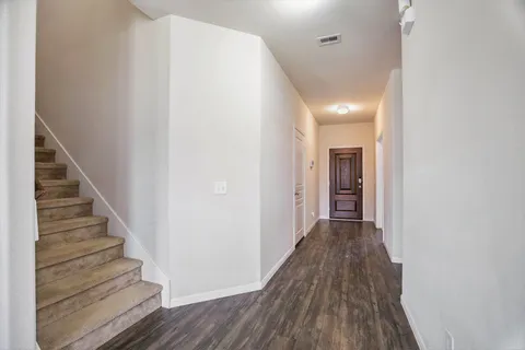 a view of a hallway with wooden floor and entryway