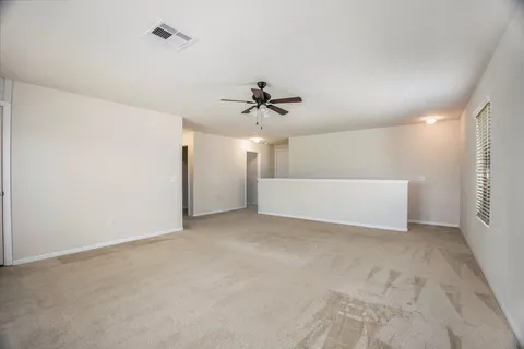 an empty room with a ceiling fan and a window