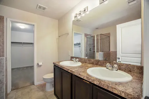 a bathroom with a granite countertop sink toilet and shower