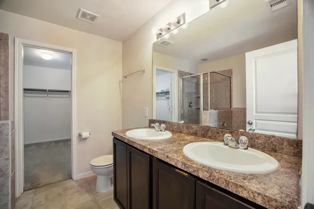 a bathroom with a granite countertop sink toilet and shower
