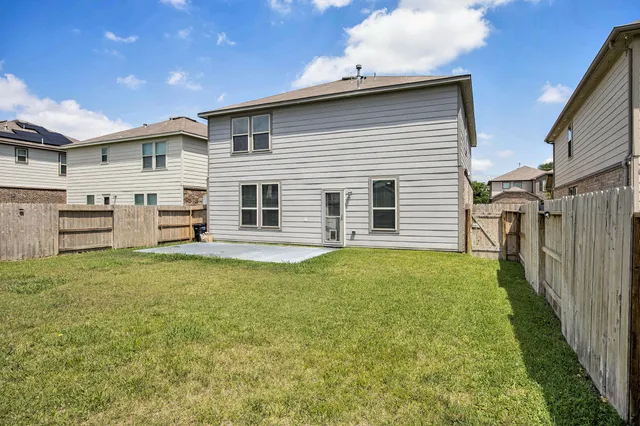 a backyard of a house with dishwasher and wooden fence