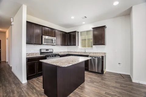 a kitchen with stainless steel appliances granite countertop a stove top oven a sink and a microwave