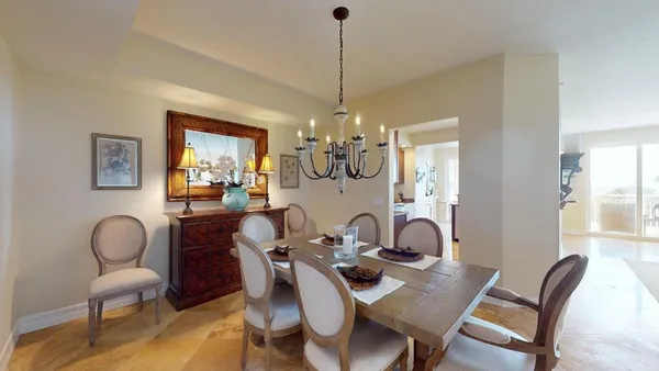 a living room with furniture a chandelier and a dining table