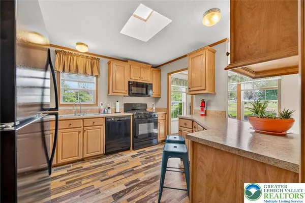 a kitchen with stainless steel appliances granite countertop a refrigerator a stove and a wooden floors