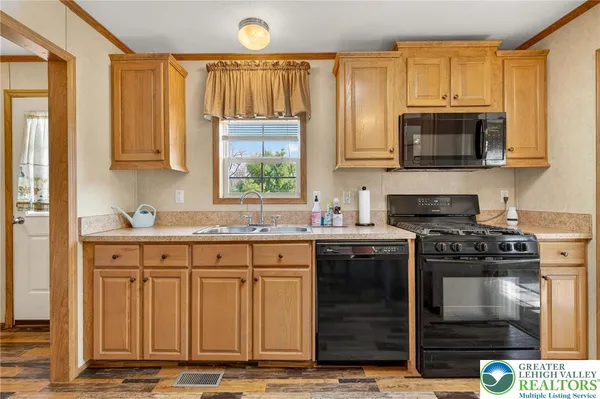 a kitchen with stainless steel appliances kitchen island granite countertop a table chairs sink and cabinets