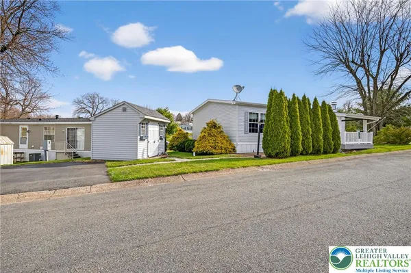 a view of road and house with a big yard