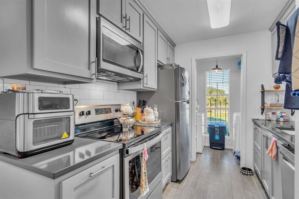 5981 Arapaho Road, Unit 1307 Dallas, TX 75248 - Photo 15 of 31 a kitchen with stainless steel appliances granite countertop a stove and a refrigerator