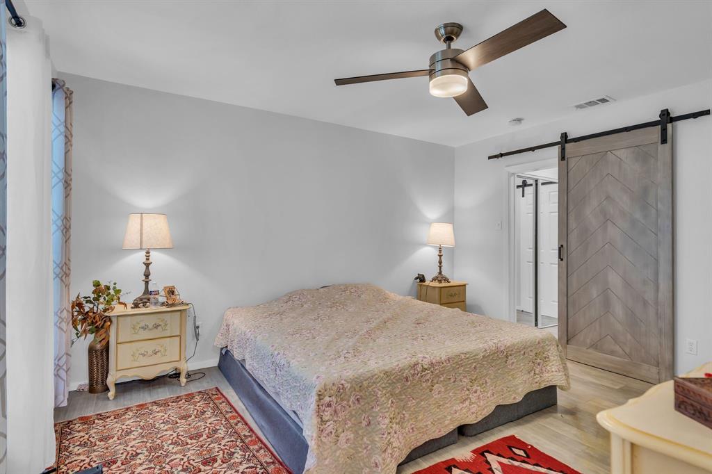 5981 Arapaho Road, Unit 1307 Dallas, TX 75248 - Photo 21 of 31 a bedroom with a bed and a chandelier