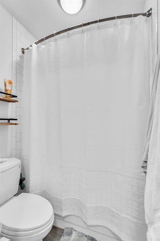 5981 Arapaho Road, Unit 1307 Dallas, TX 75248 - Photo 23 of 31 a white toilet sitting next to a shower