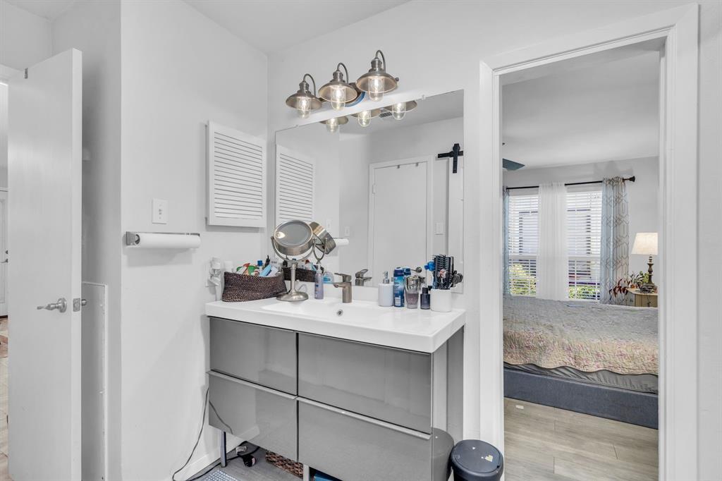 5981 Arapaho Road, Unit 1307 Dallas, TX 75248 - Photo 24 of 31 a bathroom with a sink mirror and vanity