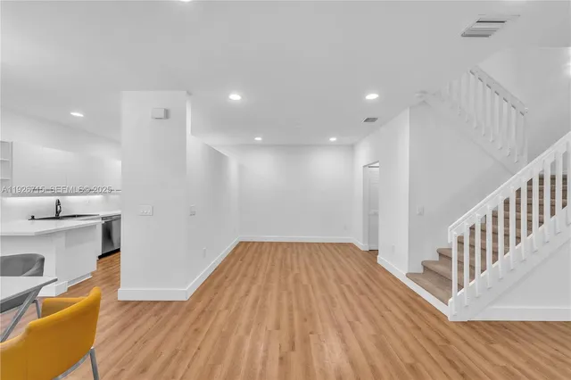 a view of a kitchen with wooden floor and electronic appliances