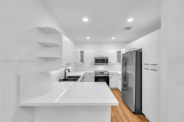 a kitchen with stainless steel appliances a stove sink and refrigerator