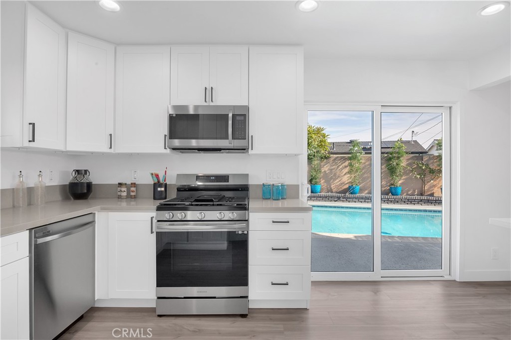 4312 Myra Avenue Cypress, CA 90630 - Photo 8 of 38 a kitchen with granite countertop a stove top oven microwave and cabinets
