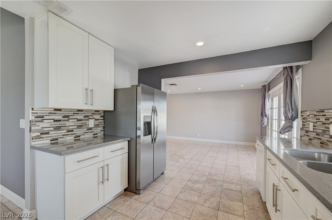 6635 Costa Brava Road Las Vegas, NV 89146 - Photo 15 of 59 A well-appointed kitchen showcasing contemporary cabinetry and resilient tile flooring, seamlessly flowing into an open living area.