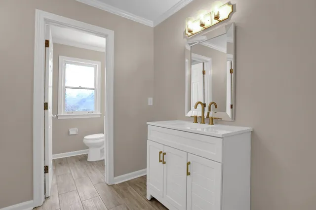 a bathroom with a toilet a sink and mirror