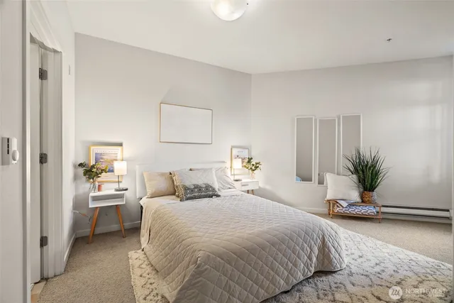 a bedroom with a large bed and a potted plant