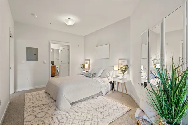 a bedroom with a large bed and a potted plant
