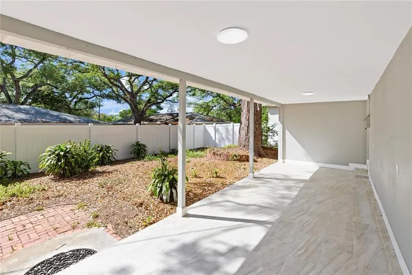 a large white room with a large windows and plants