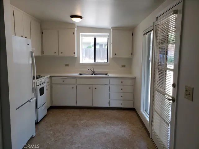 a kitchen with white cabinets and white appliances