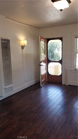a view of a hallway with bathroom and wooden floor