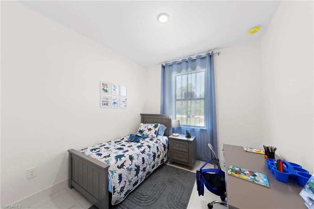 907 Homestead Road South Lehigh Acres, FL 33974 - Photo 17 of 29 a bedroom with a bed and a window