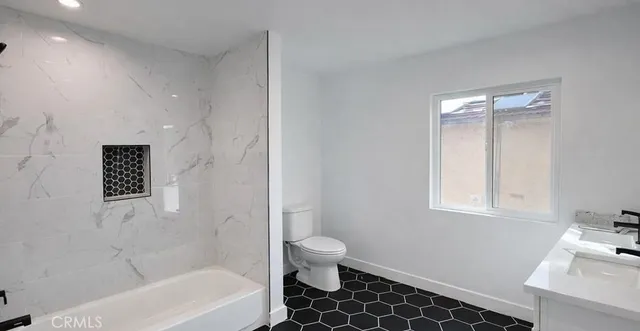 a bathroom with a bathtub sink vanity and toilet