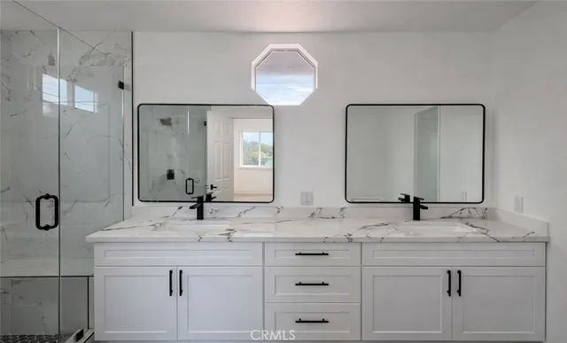 a bathroom with double sink and a mirror