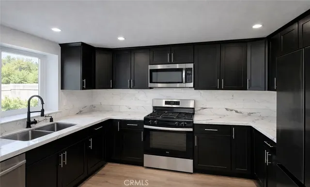 a kitchen with a sink and a stove top oven with wooden floor