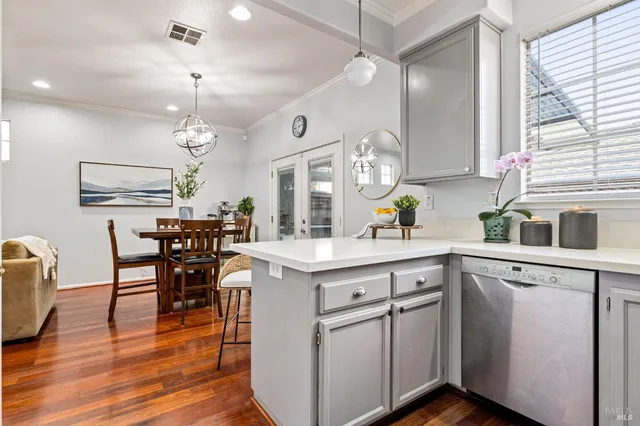 a kitchen with a table chairs refrigerator and wooden floor