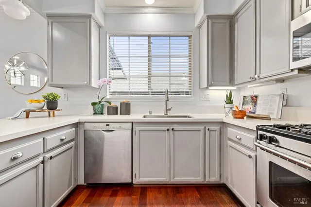 a kitchen with white cabinets white appliances and sink