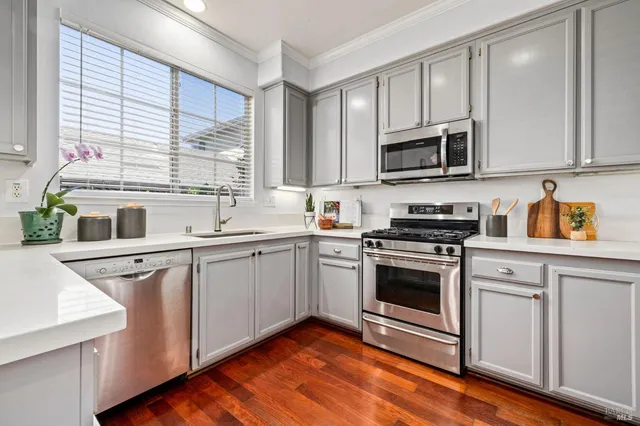 a kitchen with stainless steel appliances granite countertop a stove a sink and a microwave