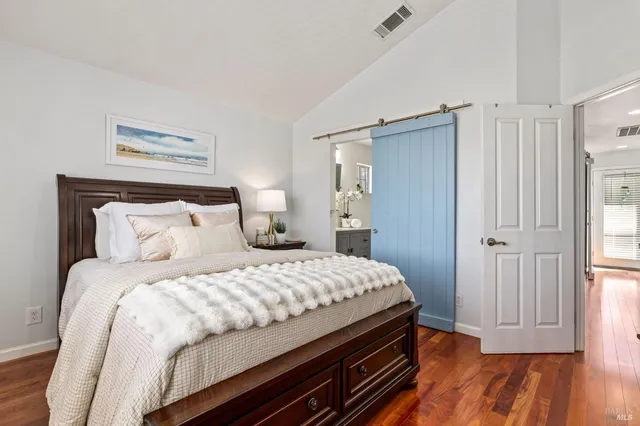 a bedroom with a bed and wooden floor