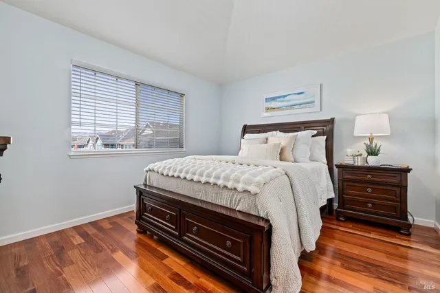 a bedroom with a bed and a dresser next to a window