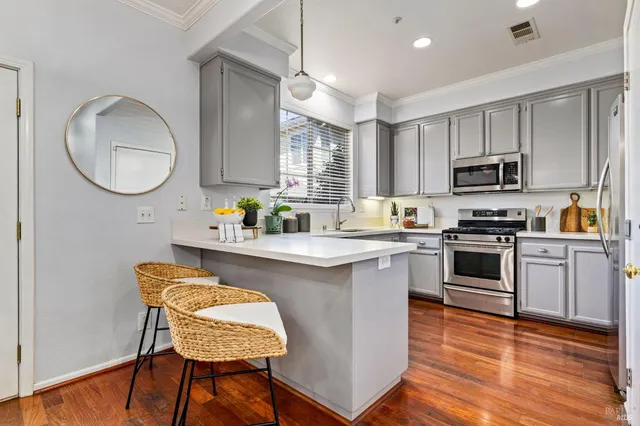 a kitchen with granite countertop wooden floors and white stainless steel appliances