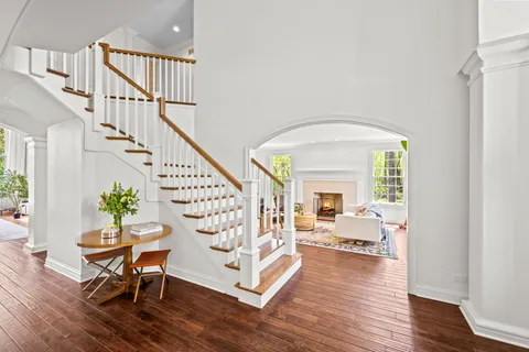 a kitchen with stainless steel appliances kitchen island granite countertop a table chairs in it and a large window