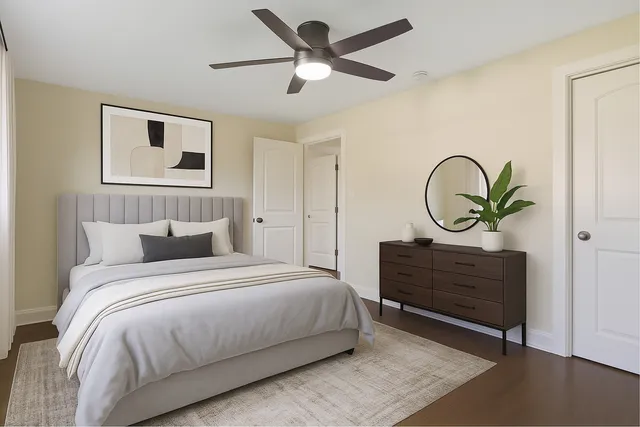 an empty room with wooden floor and ceiling fan