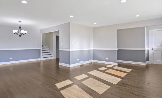 a dining room with wooden floor a chandelier a wooden table and chairs